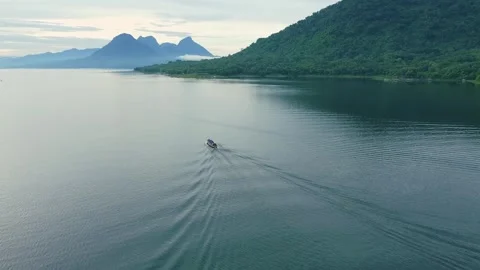 High Angle Perspective of a Traditional Boat Moving Towards Mountain Ranges Stock Footage 337538861
