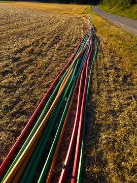 High-angle perspective view of colorful fiber optic duct pipes laid along an  Stock Photos