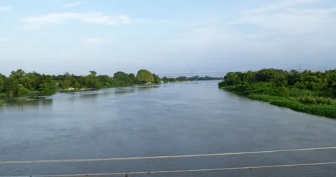 High angle perspective of the wide Bang Pakong river flowing through lush green Stock Footage 347963523