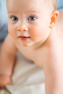 High angle portrait of a cute crawling baby with big blue eyes Stock Photos