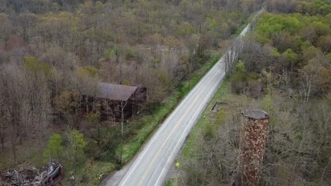 A High Angle Rearward Drone Flight Away from Abandoned Buildings Stock Footage 256679002