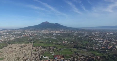 HIGH ANGLE REVERSE TILT SHOT OF ANCIENT POMPEII CITY RUINS AND MT VESUVIUS Stock Footage 61875436
