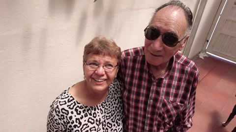 High angle scene of latin elderly or senior couple smiling at camera indoors Stock Footage 147570736