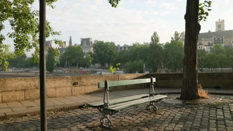 High-angle scenic view of a classic green bench on a cobblestone river quay in P Stock Footage 338007321