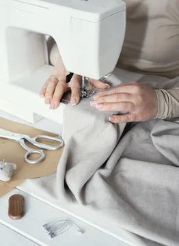 High angle seamstress using sewing machine Stock-Fotos
