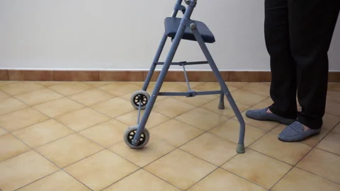 High angle on senior woman using a walker in hallway at hospital Stock Footage 103614193