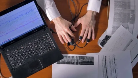 High angle of shaking hands and lie detector's diagrams. Stock Footage 77134958