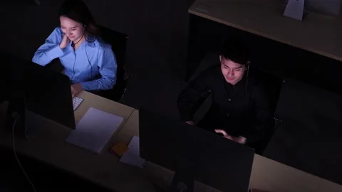 High angle shot of 2 Asian call centers, tired, streching up, taking a break Stock Footage 147189731