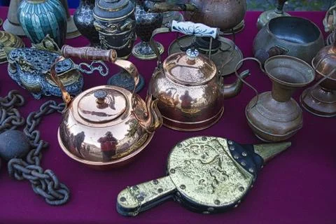 High angle shot of antique objects, including kettle, vase, and more on a purple Foto stock