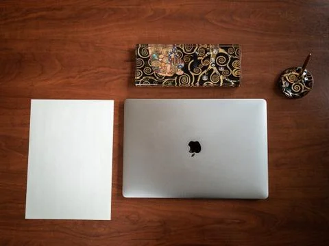 High angle shot of an Apple MacBook and other objects on a wooden office tabl Photos
