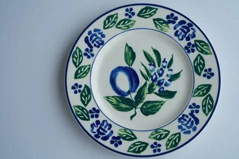 A high angle shot of a big white plate with beautiful floral patterns on grey Stock Photos