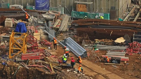 High angle shot of builders managing metal rods and heavy equipment at Stock Footage 337990089