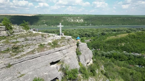 High-angle shot captures a cliff top with a white cross Stock Footage 340240259