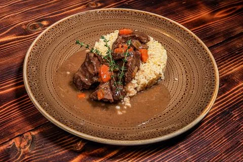 High angle shot capturing tender braised meat pieces with carrots and herbs,  Stock Photos