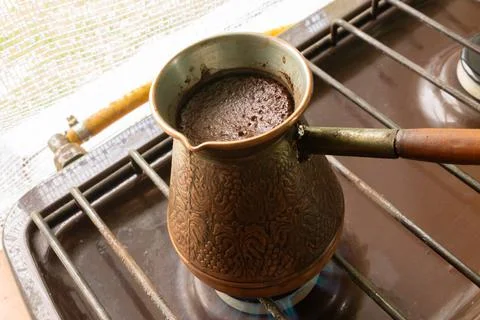 High angle shot of coffee is brewed in a copper Turk on the gas stove Stock Photos