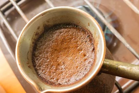 High angle shot of coffee is brewed in a copper Turk on the gas stove Stock Photos