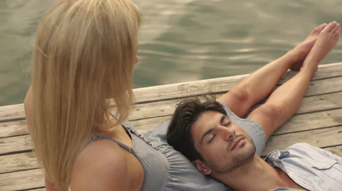 High angle shot of couple relaxing on dock. Stock Footage 43637383