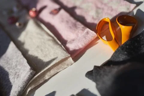 High angle shot of a creative workspace with orange scissors and wool fabric  写真素材