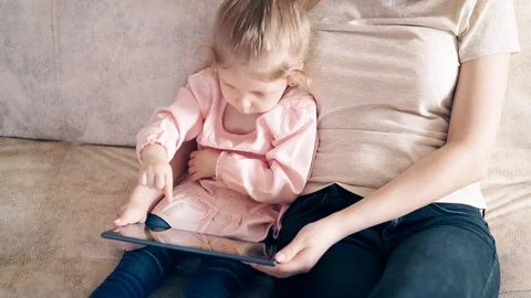 High-angle shot, CU, 4k: Young attractive mother and sweet daughter are sitting Stock Footage 105119175