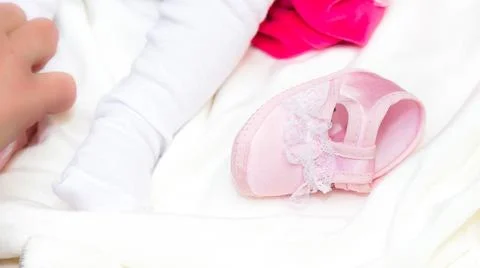 High angle shot of a cute tiny shoe next to a baby Stock Photos