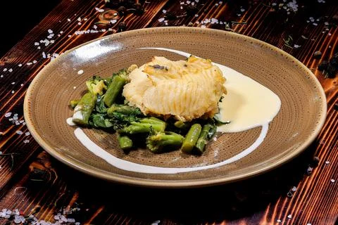 High-angle shot of a delectable fish fillet paired with vegetables, drizzled  Stock Photos