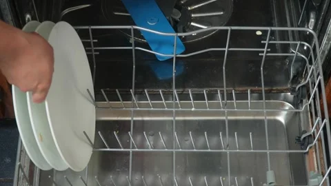 High-angle shot of dirty, white plates being loaded into a dishwasher Vídeos de archivo 313908060