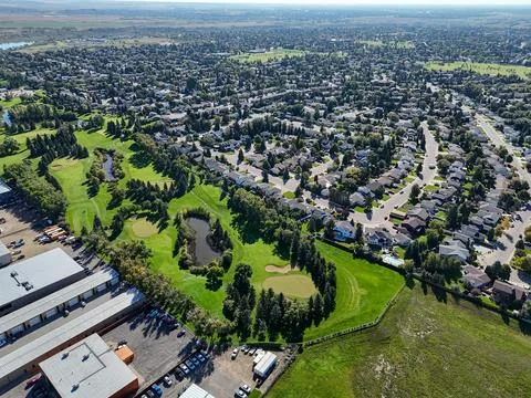 High angle shot displays golf course nestled among homes and industrial zones Stock Photos