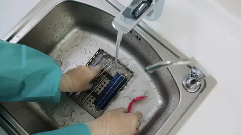High-angle shot of doctor's hands puts a tray dental tools in the sink and wash Stock Footage 131683619