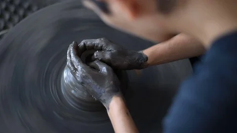 High angle shot of female shaping clay cups on spinning pottery wheel Stock Footage 79838254