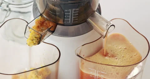 High angle shot of fresh juice being made in a brightly lit kitchen. Stock Footage