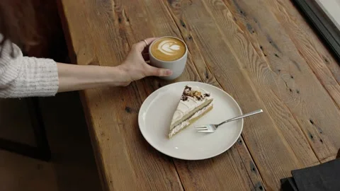 High angle shot of hand serving coffee on the wooden table in front of window 4k Stock Footage 218236785