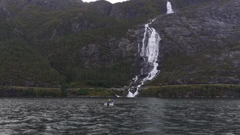 High angle shot of Langfossen and fishing boat on calm fjord waters Stock Footage 320245068
