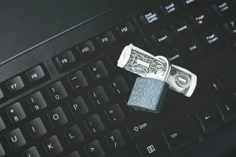 High angle shot of a lock around a dollar bill on a black laptop 写真素材