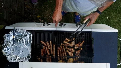High angle shot of man grilling chicken and burgers on barbecue Stock Footage 111934082