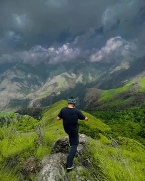 High Angle Shot of a Man Standing on a Mountain Peak Stock Photos