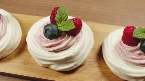High angle shot of mini Pavlova cakes decorated with berries and mint. Parallax Stock-Footage 143213280