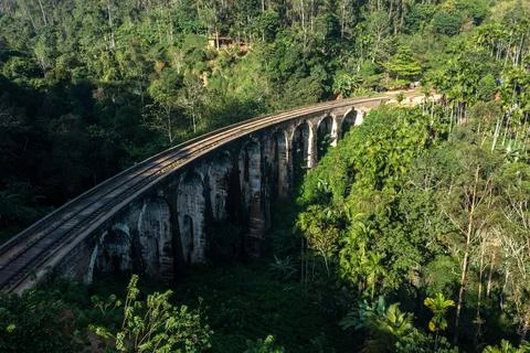 High angle shot of Nine Arch Bridge surrounded by lush green jungle illuminated Stock Photos