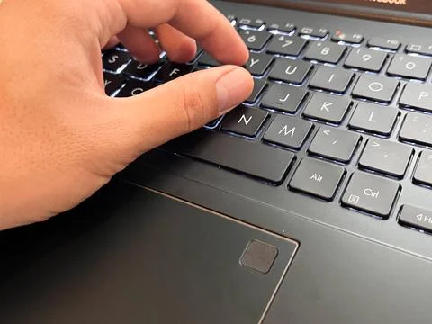 High-angle shot of a person's hand interacting with a modern laptop keyboard Stock Photos