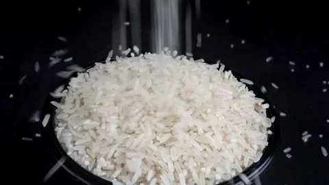 High angle shot of pouring rice into a bowl isolated black background 库存影片 277675494