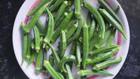 High angle shot of raw ladyfinger (okra) on a plate over dark background 스톡 동영상 332101336