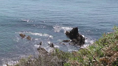 High angle shot of rock out cropping with waves crashing about in white water Stock Footage 67581608
