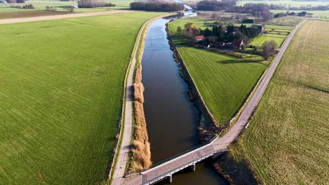 High-angle shot of a rural landscape featuring a bridge crossing a straight Stock-Footage 329526593