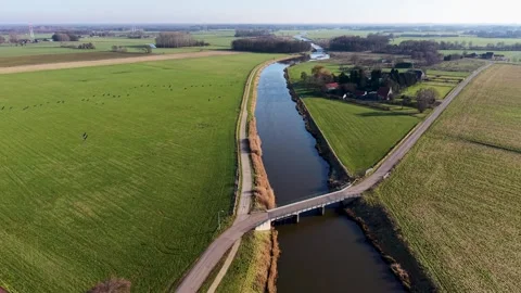 High-angle shot of a rural landscape featuring a bridge crossing a straight 스톡 동영상 330282725