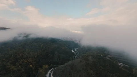 High angle shot of a serpentine road in a foggy valley with autumn forest Stock Footage 328373339