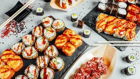 High-angle shot of a set of delicious fresh sushi rolls served on a black board 스톡 사진