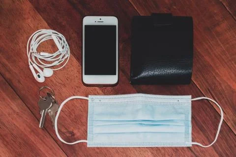 A high angle shot of a smartphone, headphones, wallet, keys and a surgical ma Stock Photos