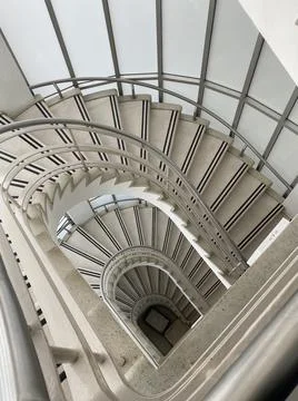 High angle shot of spiral, white-colored stairs of a building Ilustración de archivo