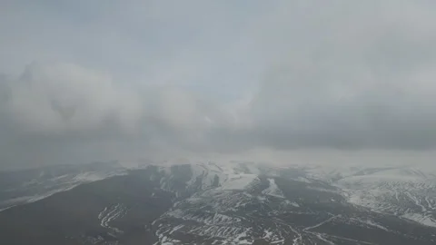 A high-angle shot of steep, dark mountain slopes dusted with fresh snow. Stock Footage 331174695