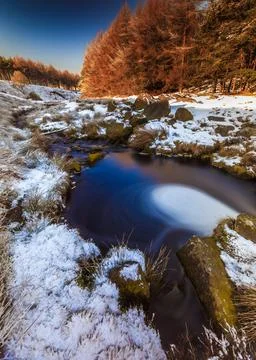 High angle shot of a tiny river near a winter forest, South Yorkshire, UK Foto stock