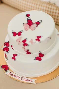 High-angle shot of a two-tier white birthday cake decorated with red Stock Photos